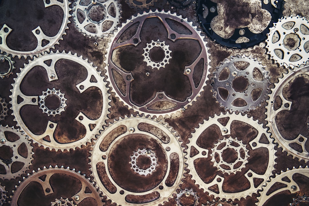 A close-up of various metallic gears arranged in an abstract pattern.