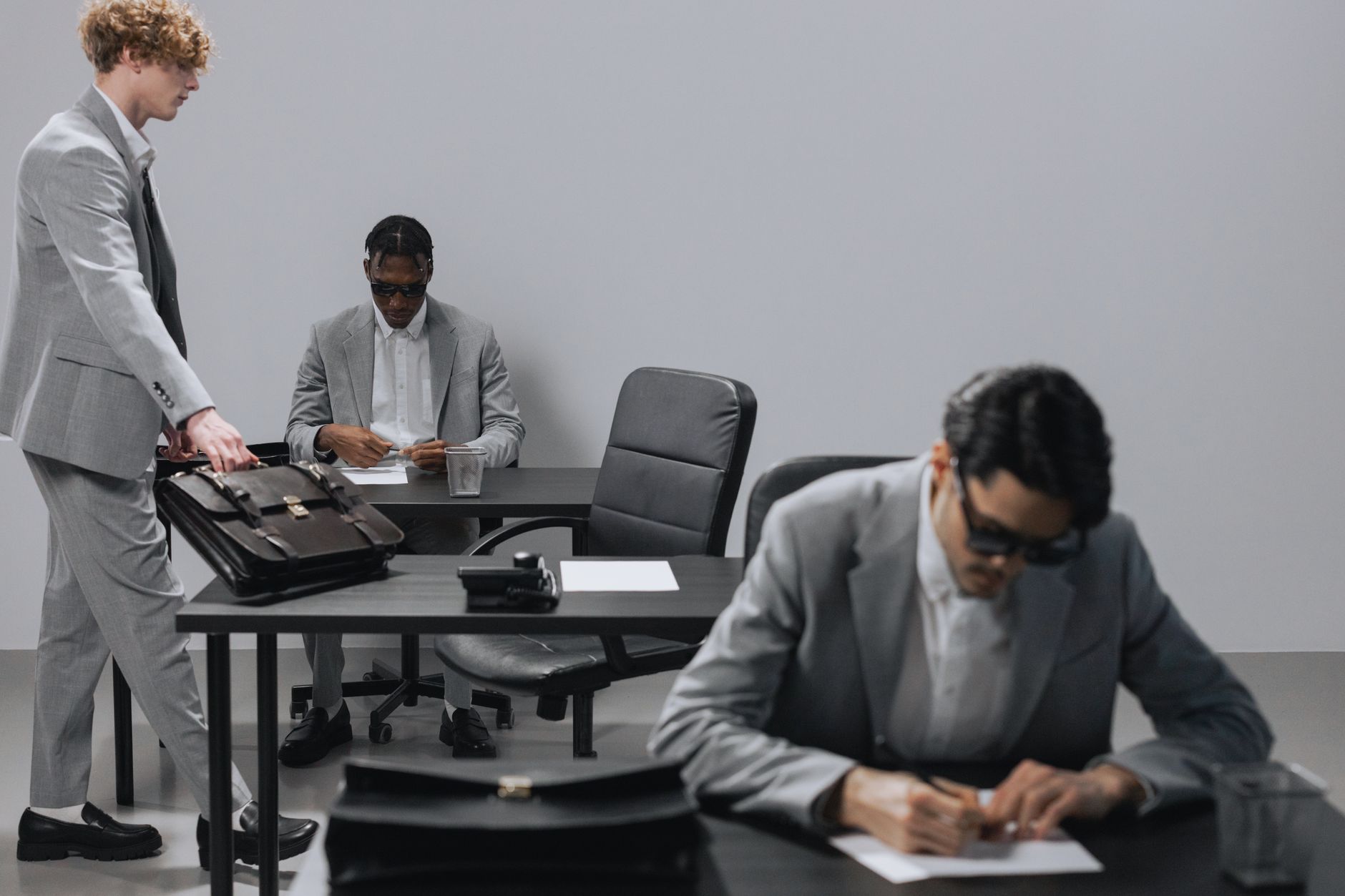 Business office with diverse employees in gray suits working at desks in an indoor setting. — Differentiating Between Convent