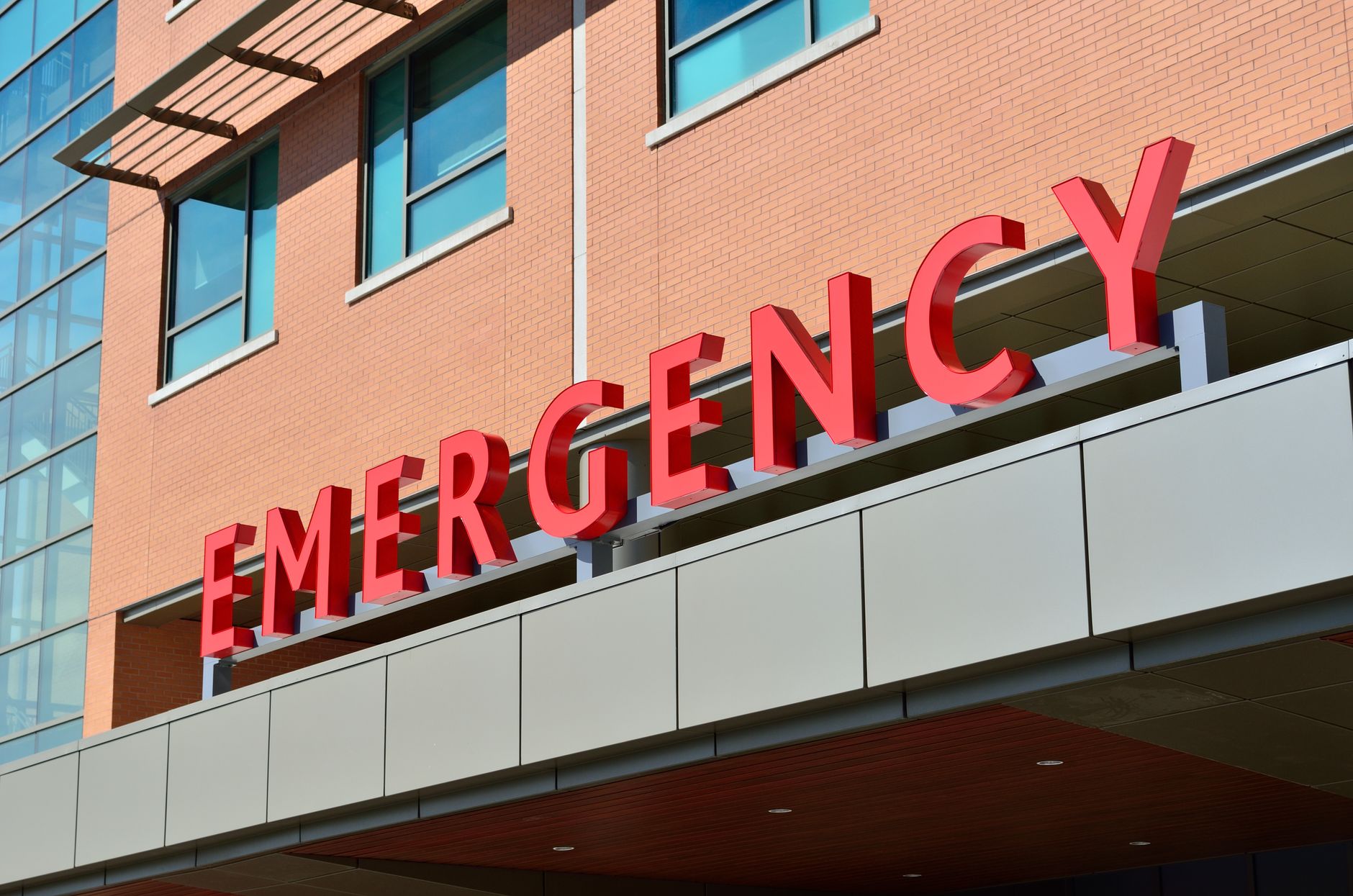Close-up of a modern hospital emergency room entrance with prominent red letters. — Dr. Timothy D. Francis - Combining Scienc