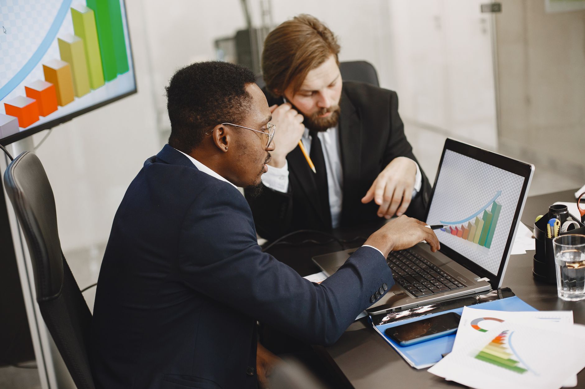 Two business professionals working on growth charts using laptop in an office setting. — How Charles Principato Balances Fami