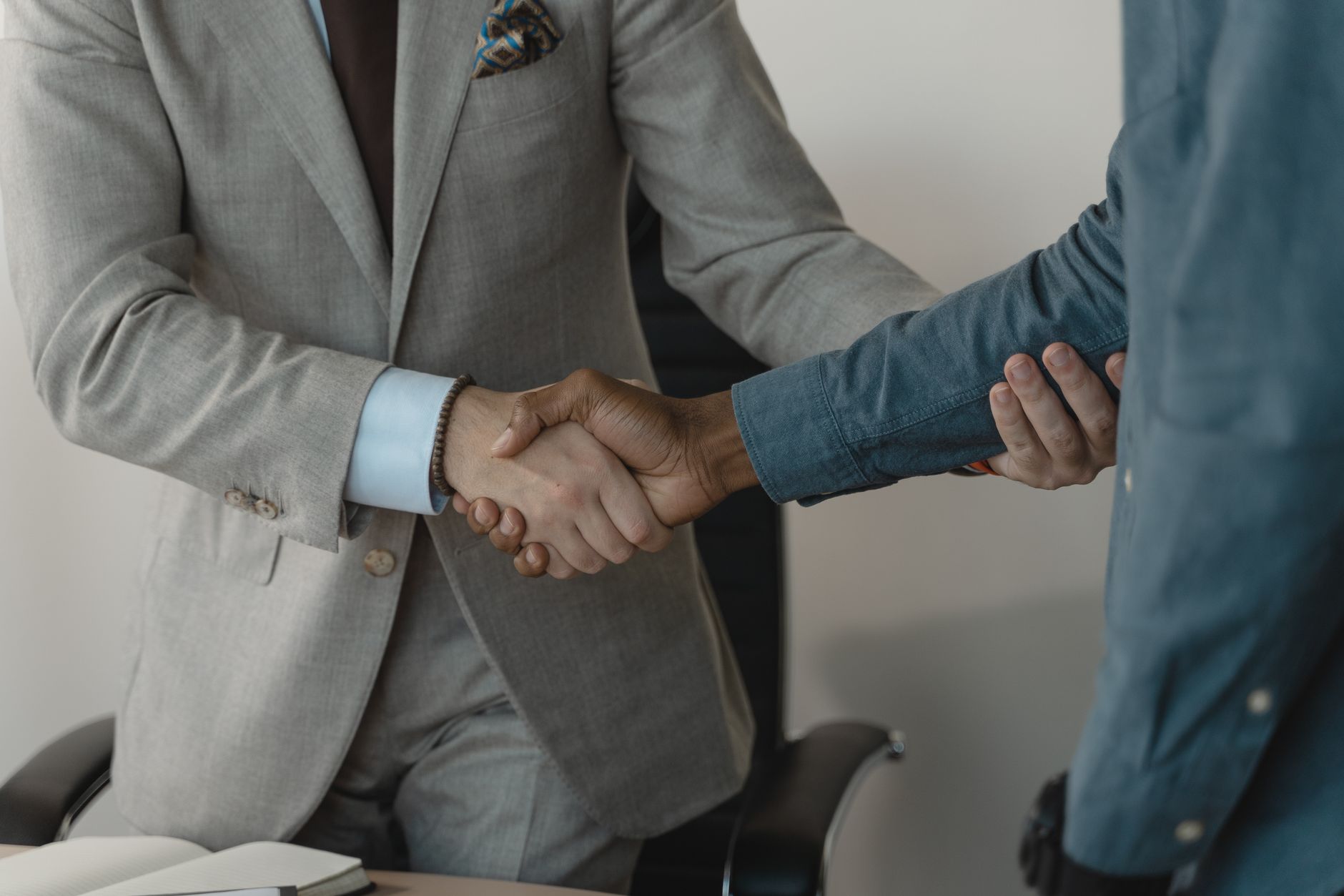 Image of a professional handshake between two businessmen in an office setting. — Join Our Vocal Mixing Masterclass
