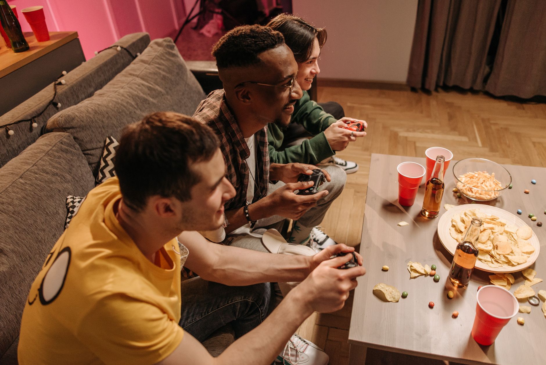 Group of friends playing video games and enjoying snacks indoors. — The Power of Koitoto in Achieving Financial Consistency